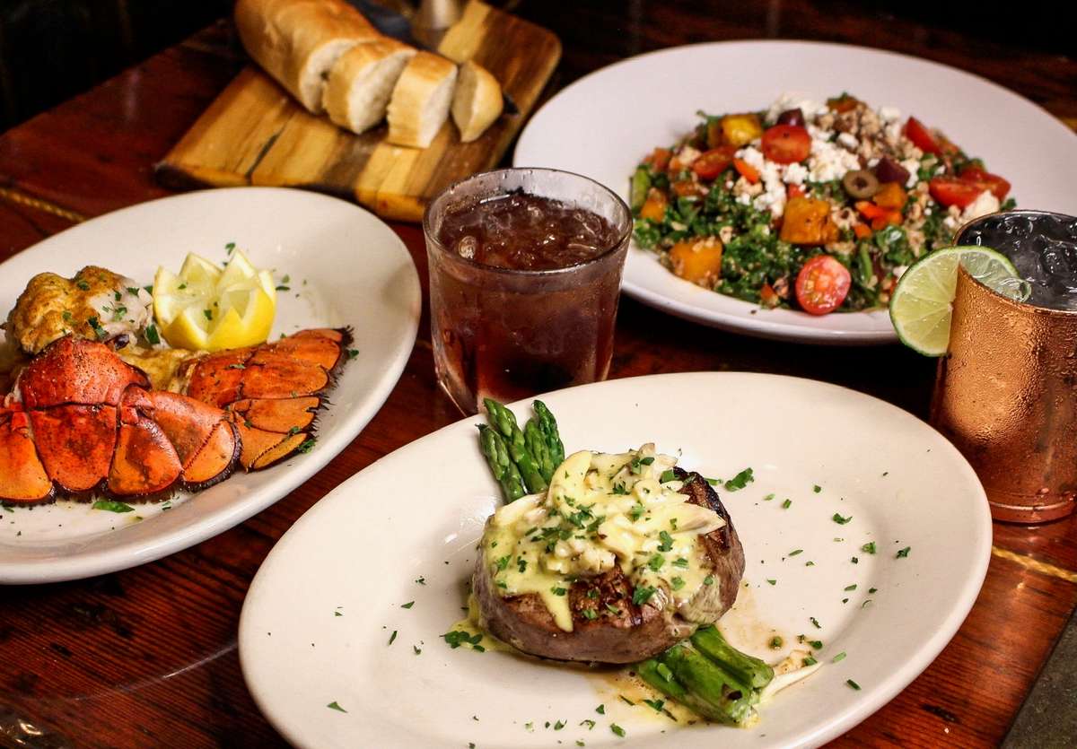 Lobster tail served with baked potato and fresh vegetables.