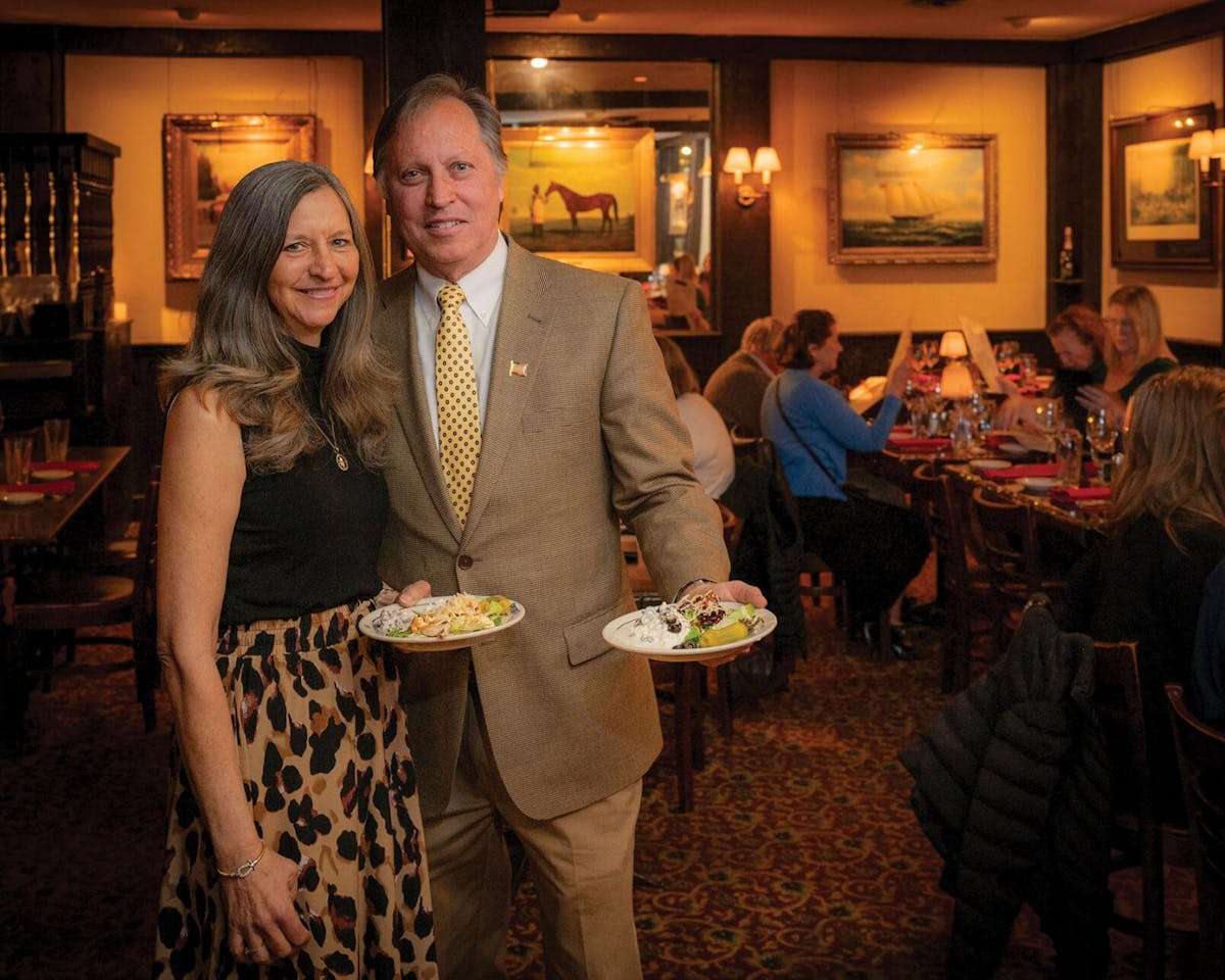 Guests holding signature dishes inside the elegant dining room at Sperry's Restaurant.