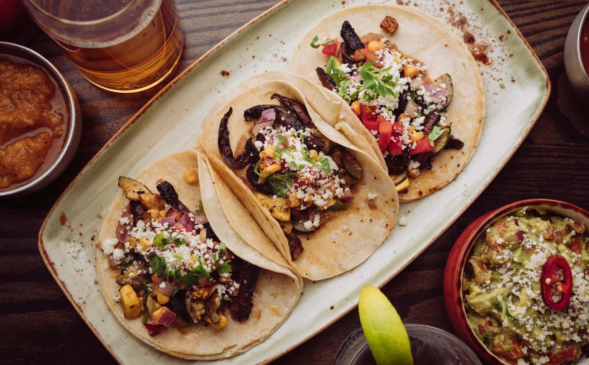 Three steak tacos on a platter
