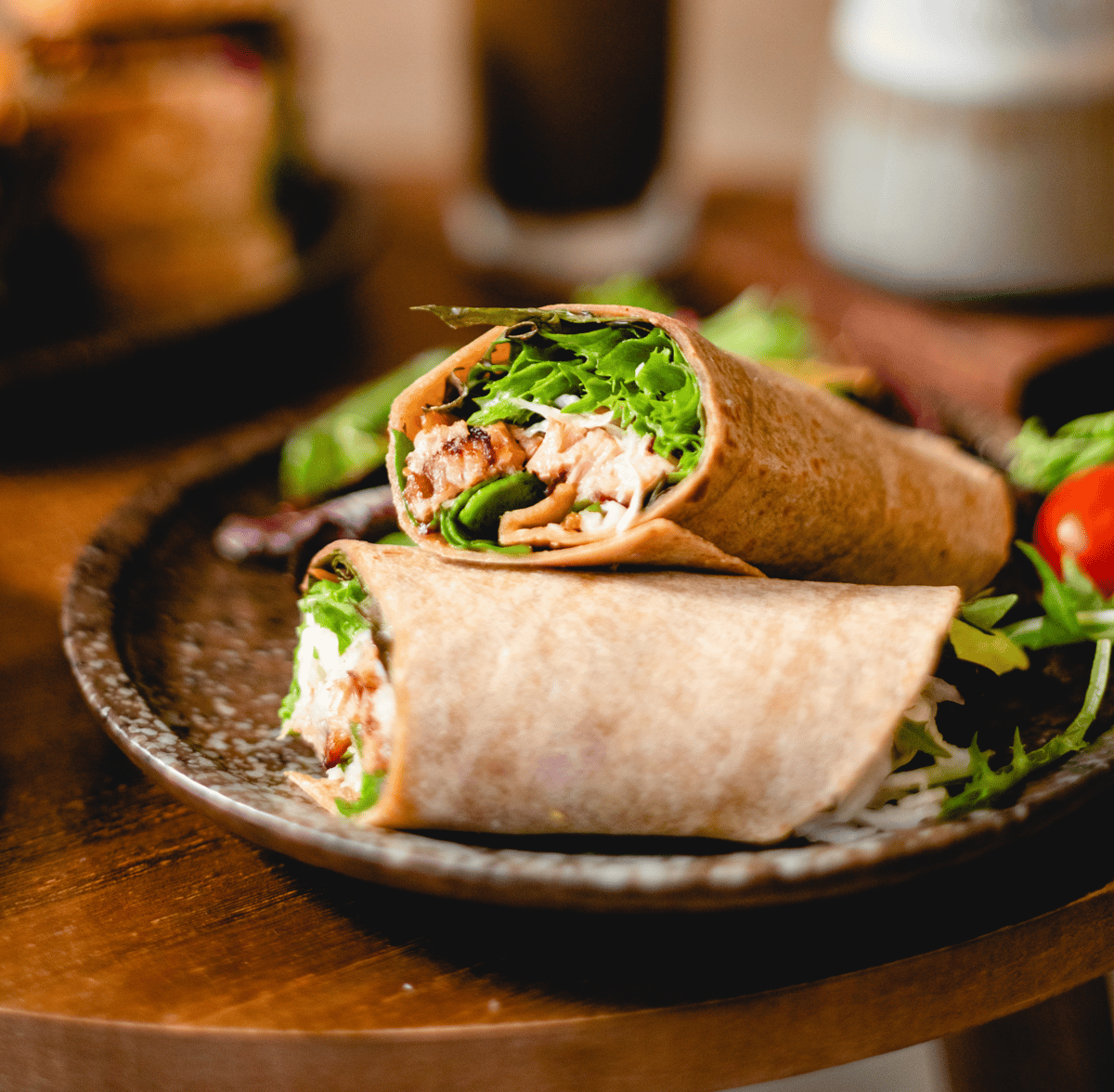 Two halves of a sandwich wrap on a plate