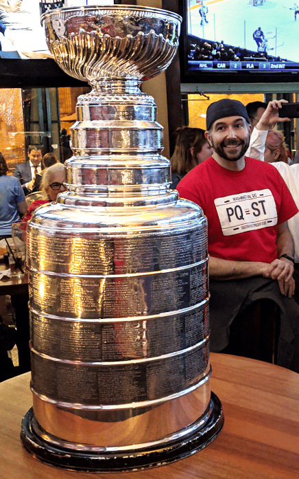 man smiling at the stanley cup