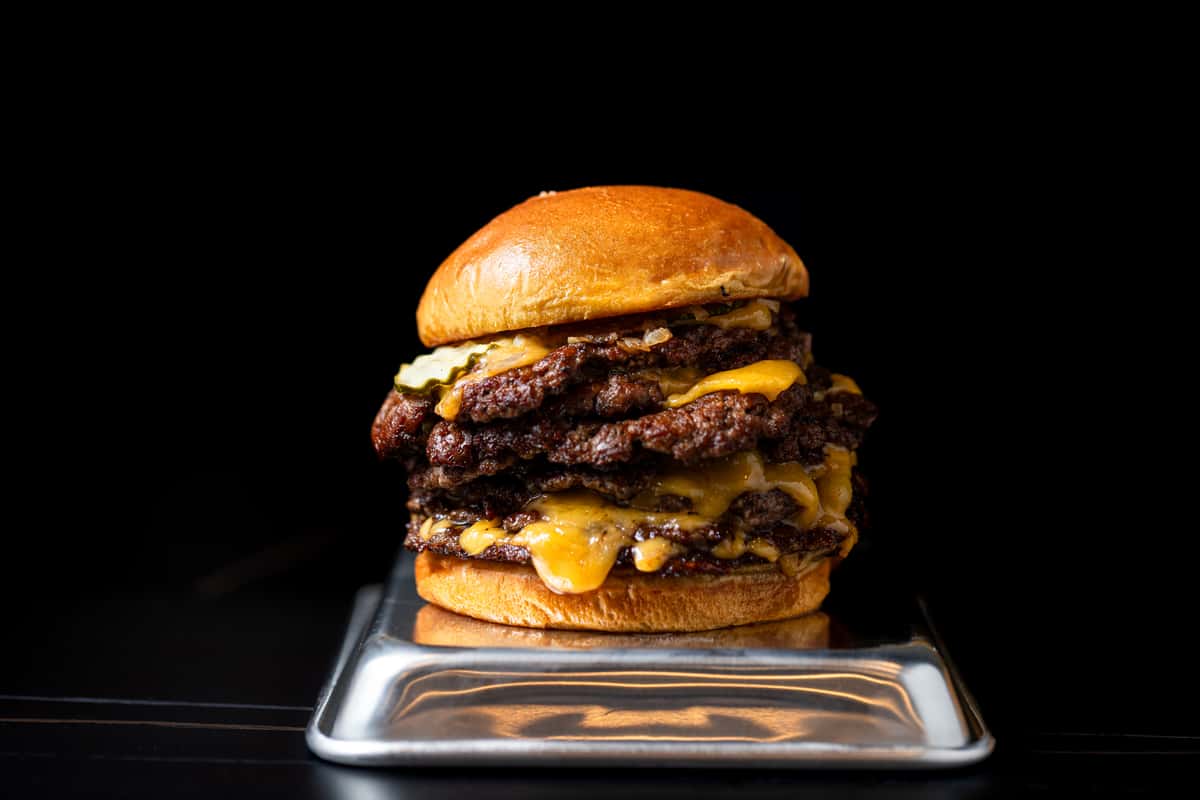 an eight patty burger on black