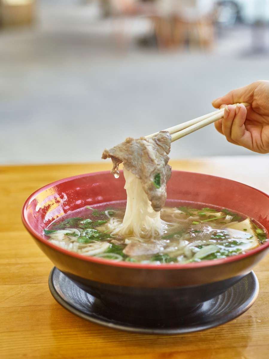 pho being lifted with chopsticks