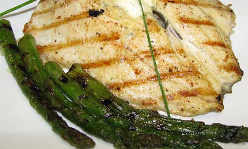 Fish and asparagus on white plate