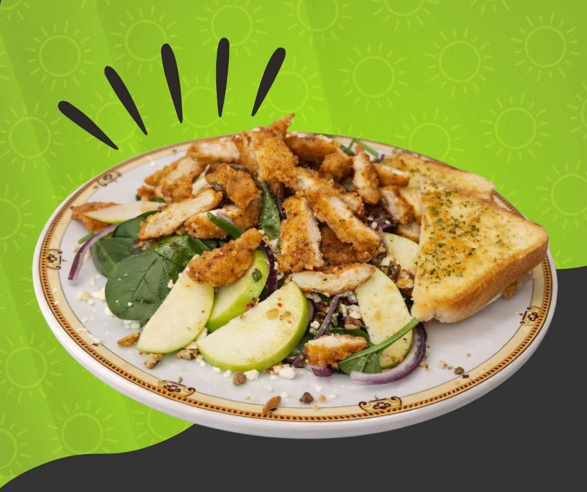 Grilled chicken and apple salad with mixed greens, sliced apples, and toasted bread at Cinnamon Restaurant Café.