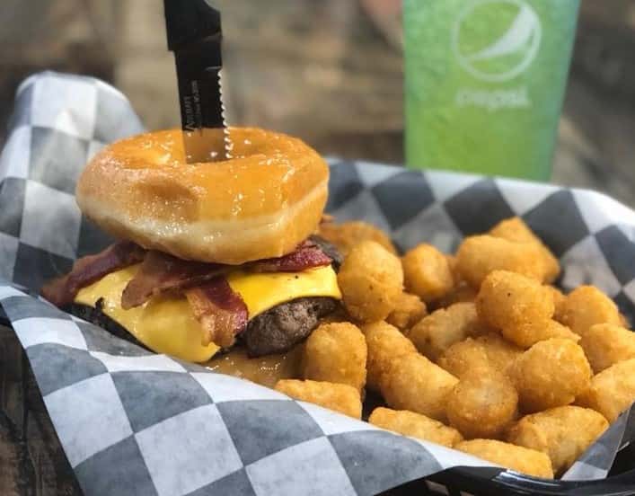 donut bacon cheeseburger with tater tots on the side.
