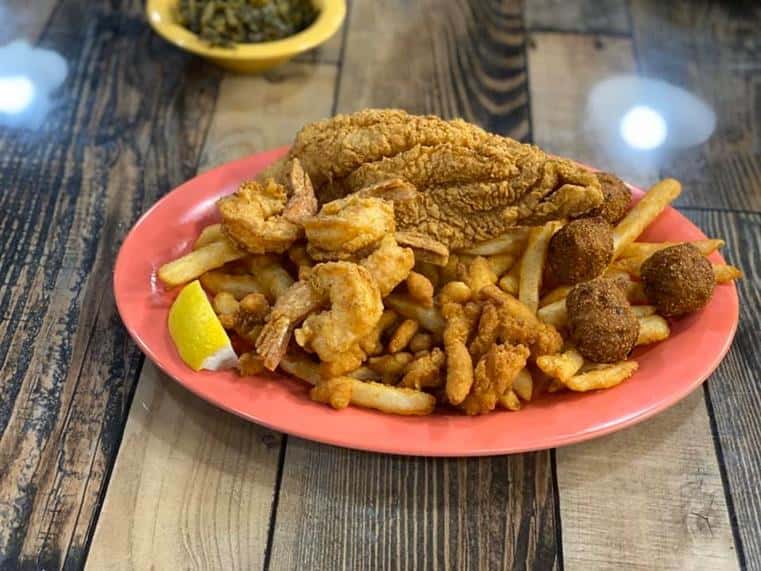 fried fish, fried shrimp, and hush puppies with french fries on the side.