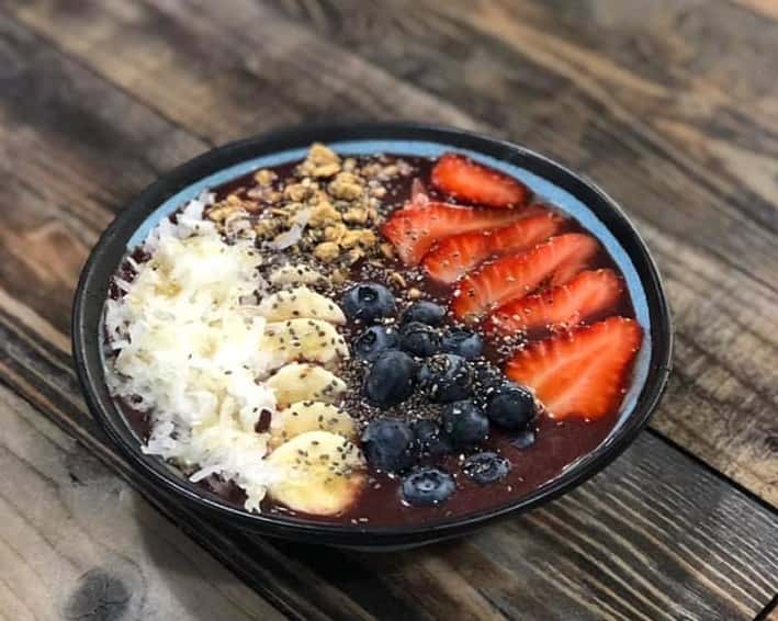 acai bowl with bananas, blueberries, strawberries, and shaved coconut
