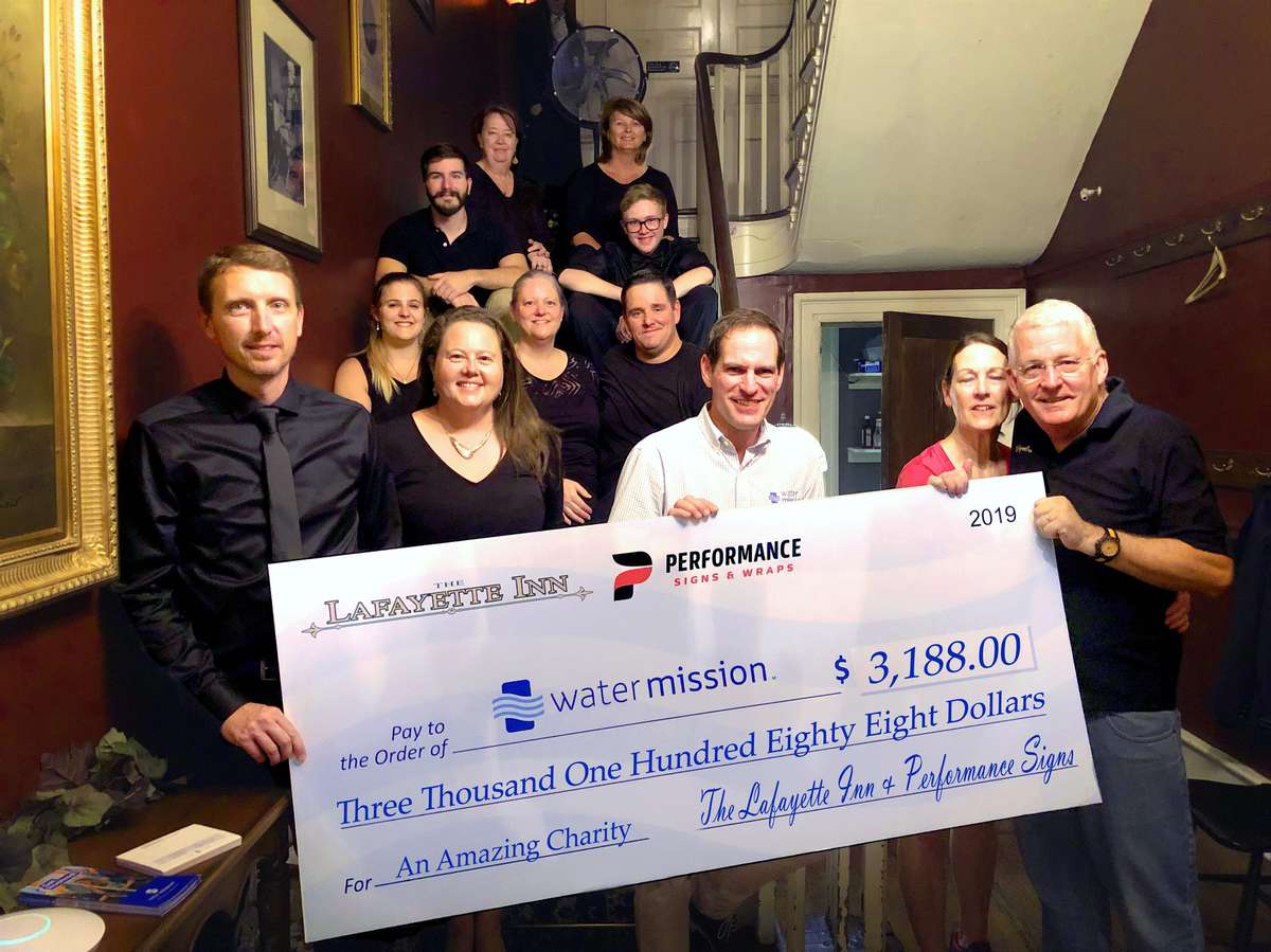 members of the Inn holding a large check
