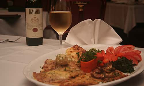 plate of appetizers with glass of wine and bottle of wine