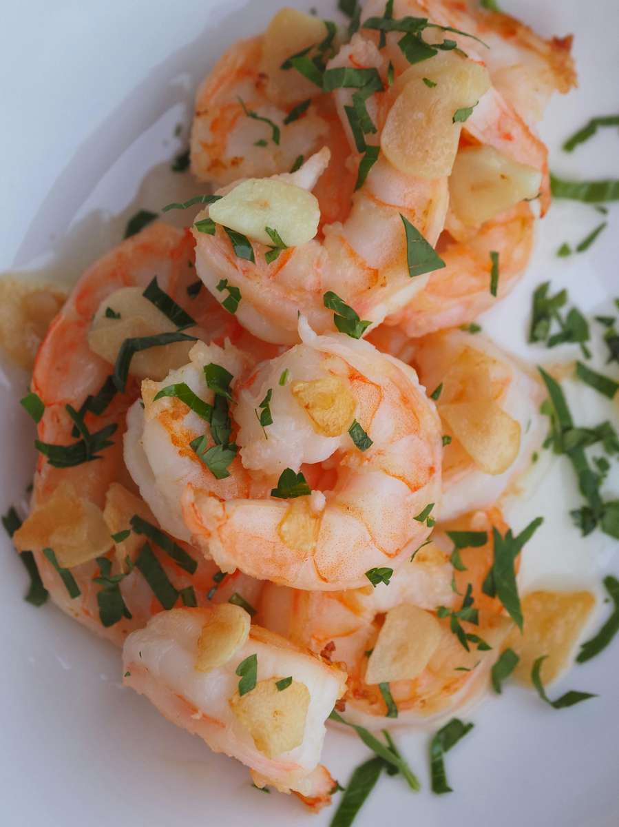 Juicy pink shrimp topped with golden garlic and fresh green herbs from Seafood Shack & More.