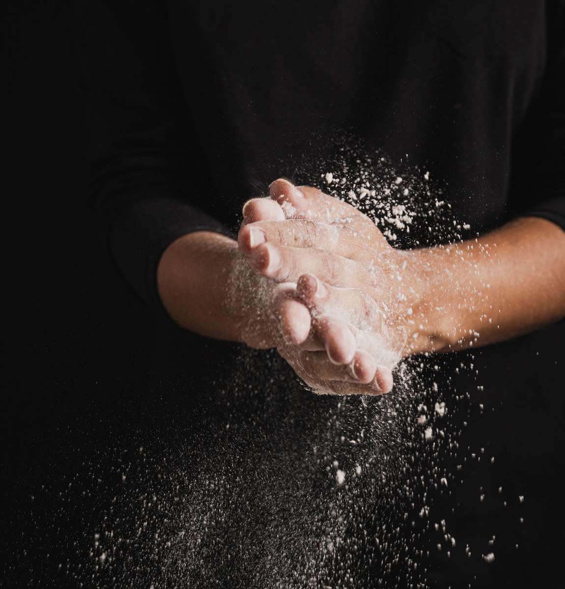 Hands shaking off flour