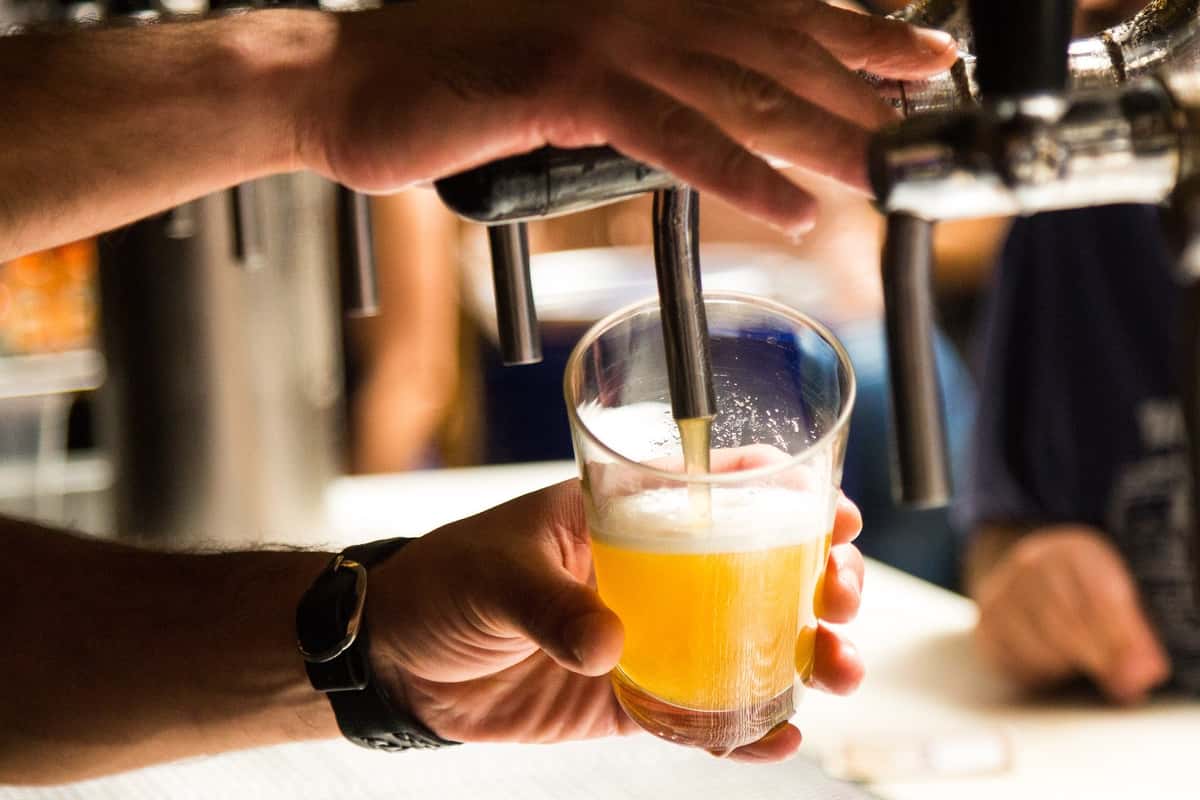bartender filling pint glass from beer tap