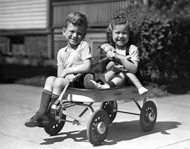 two little kids sitting on wagon