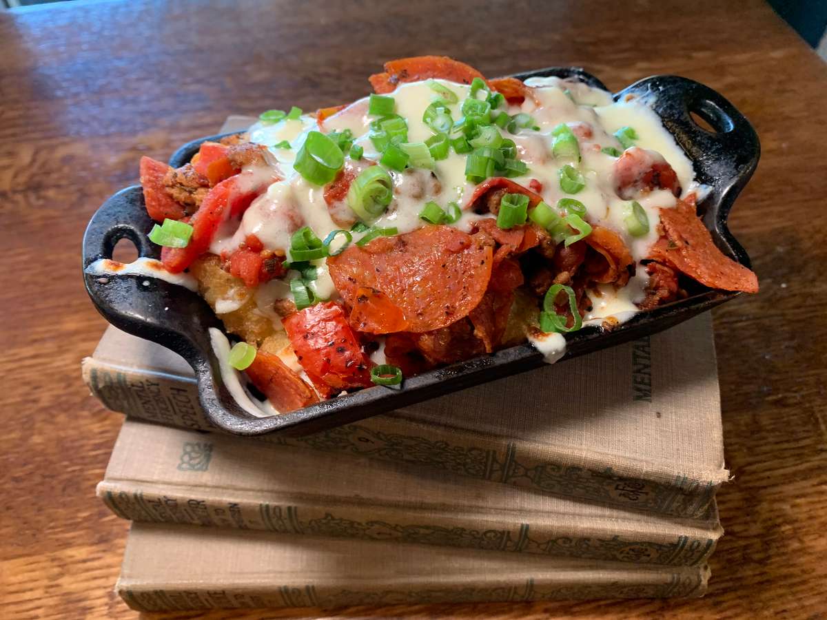 Loaded skillet topped with seasoned meat, melted cheese, pico de gallo, and green onions.