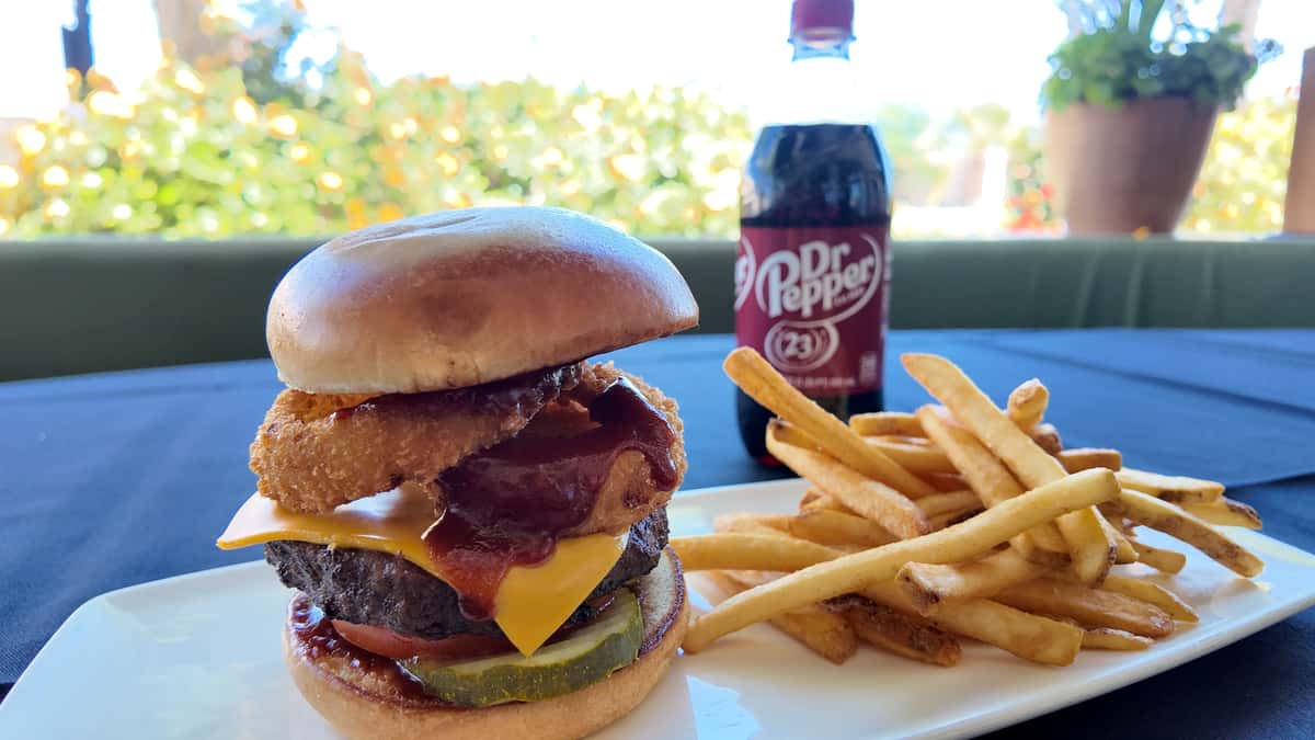 BBQ burger served with crispy fries and a canned beverage.