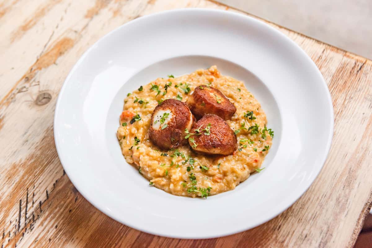 Seared scallops served over creamy risotto at Twisted Soul Cookhouse & Pours