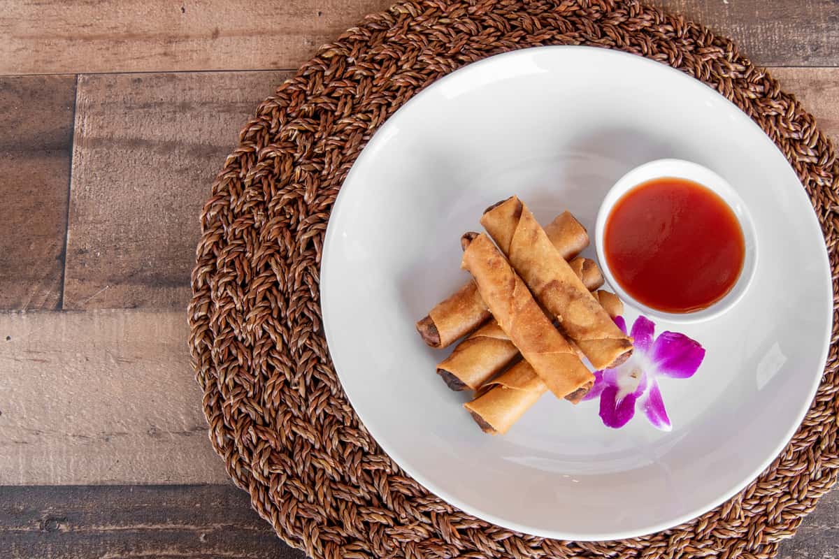 Pork lumpia rolls plated with sauce at Kalei's Kitchenette, crispy Hawaiian appetizer San Diego