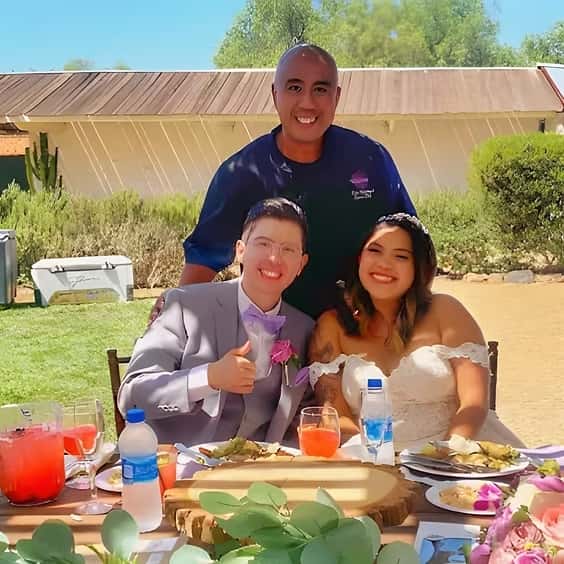 Chef Andy posing for a picture with a newly married couple