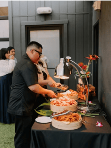 Staff member setting up a display for catered food