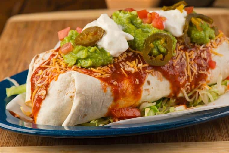 wet burrito topped with sour cream and guacamole