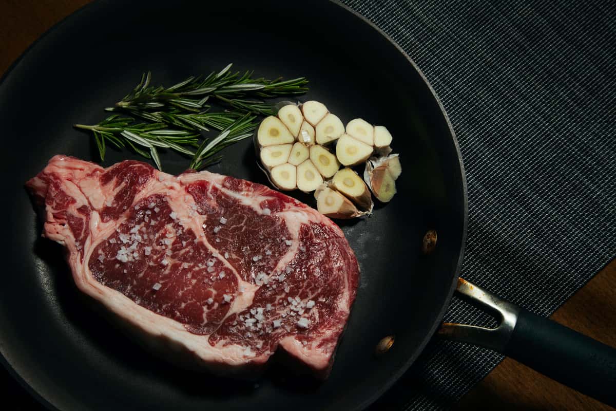Raw steak with garlic and rosemary