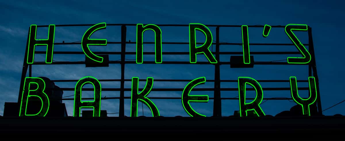 Henri's green Neon sign on top of our Buckhead store