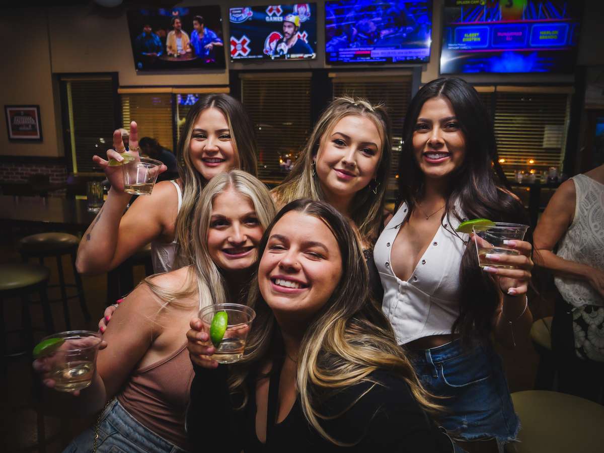 Guests posing with cocktails and friends