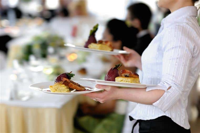 server carrying several plates of food