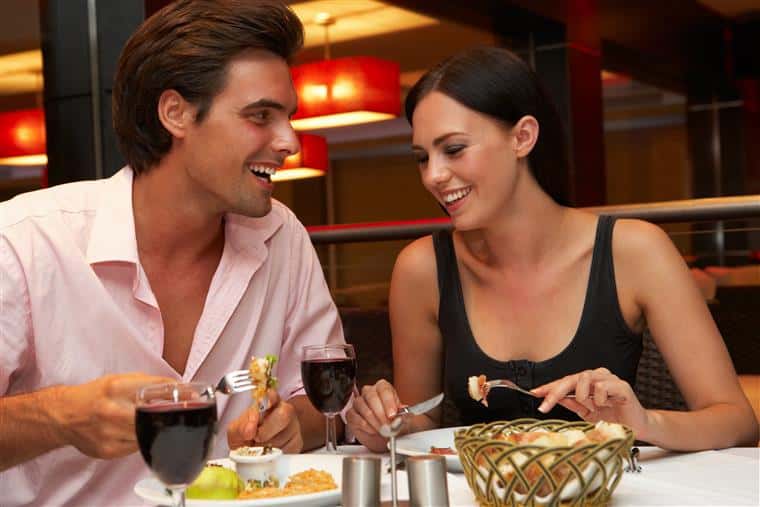 male and female smiling having dinner