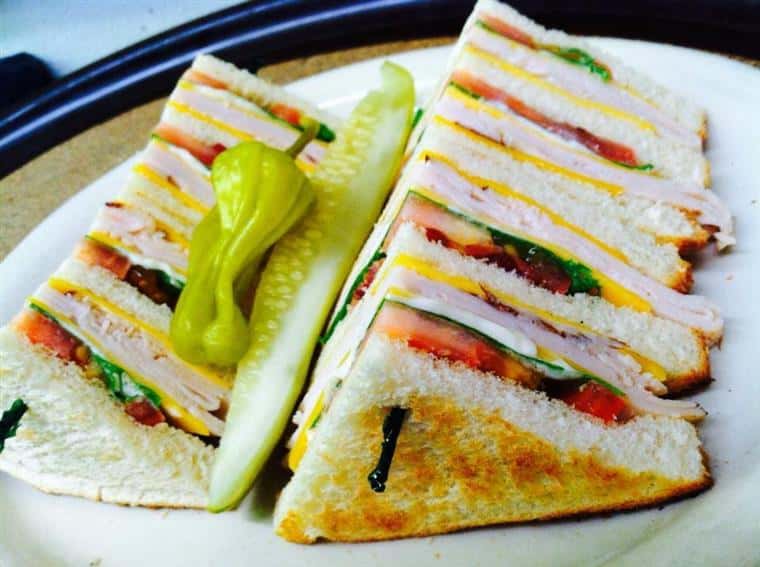 club sandwich with a pickle and a pepper