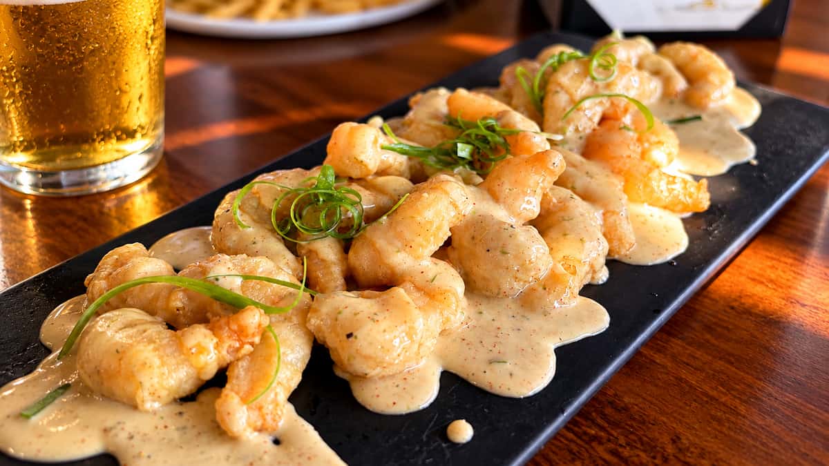 Boom boom shrimp: crispy fried shrimp tossed in a creamy spicy sauce and garnished with green onions
