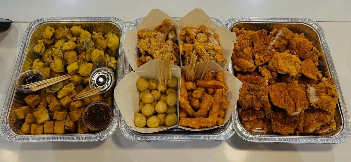Assorted Taiwanese street food catering trays from Shihlin Taiwan Street Snacks, including crispy chicken, tofu, sweet potato fries, and other shareable favorites.