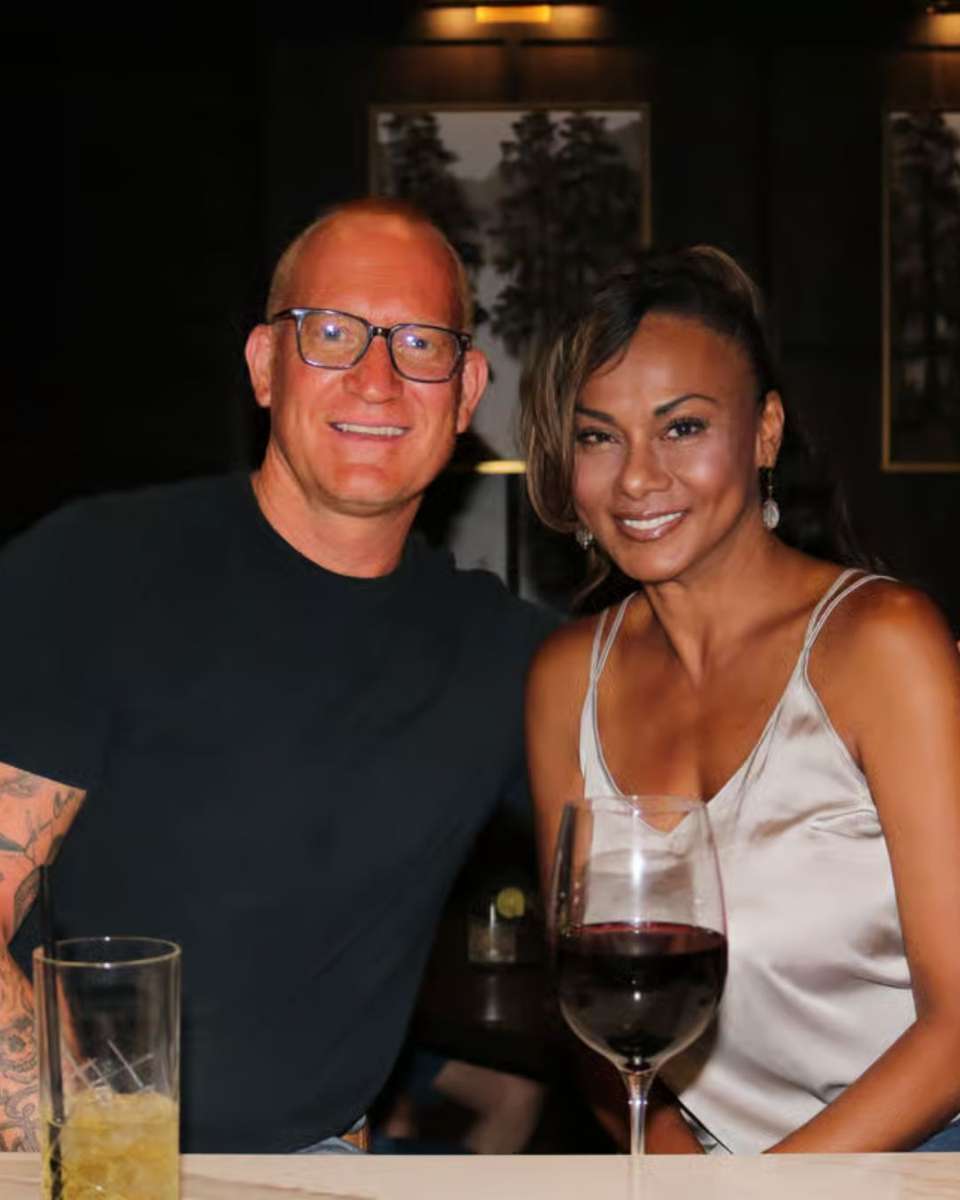 Image of our two guests enjoying cozy dining table set with elegant plates, wine glasses.
