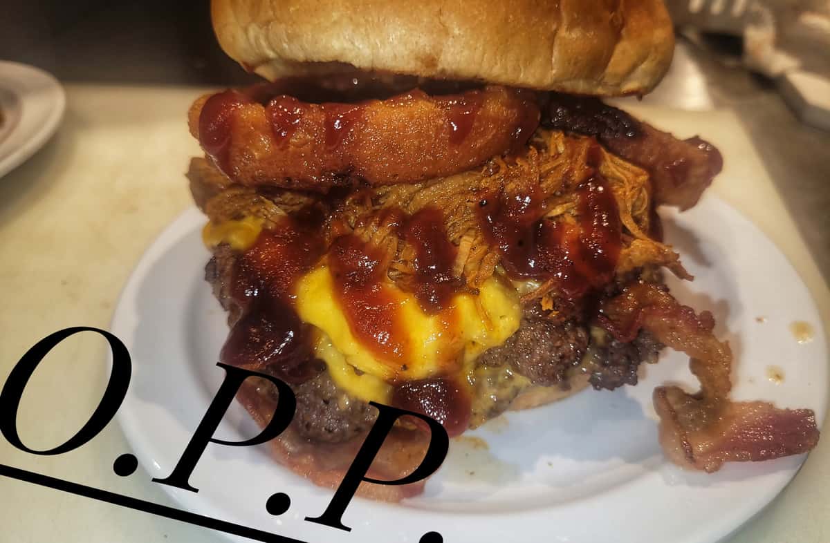 Cheeseburger topped with melted cheese and grilled pineapple, photographed in the kitchen