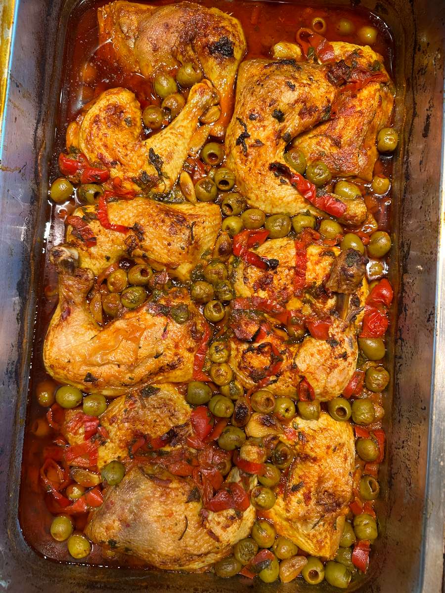 Chicken breast on a tray with olives and sauce