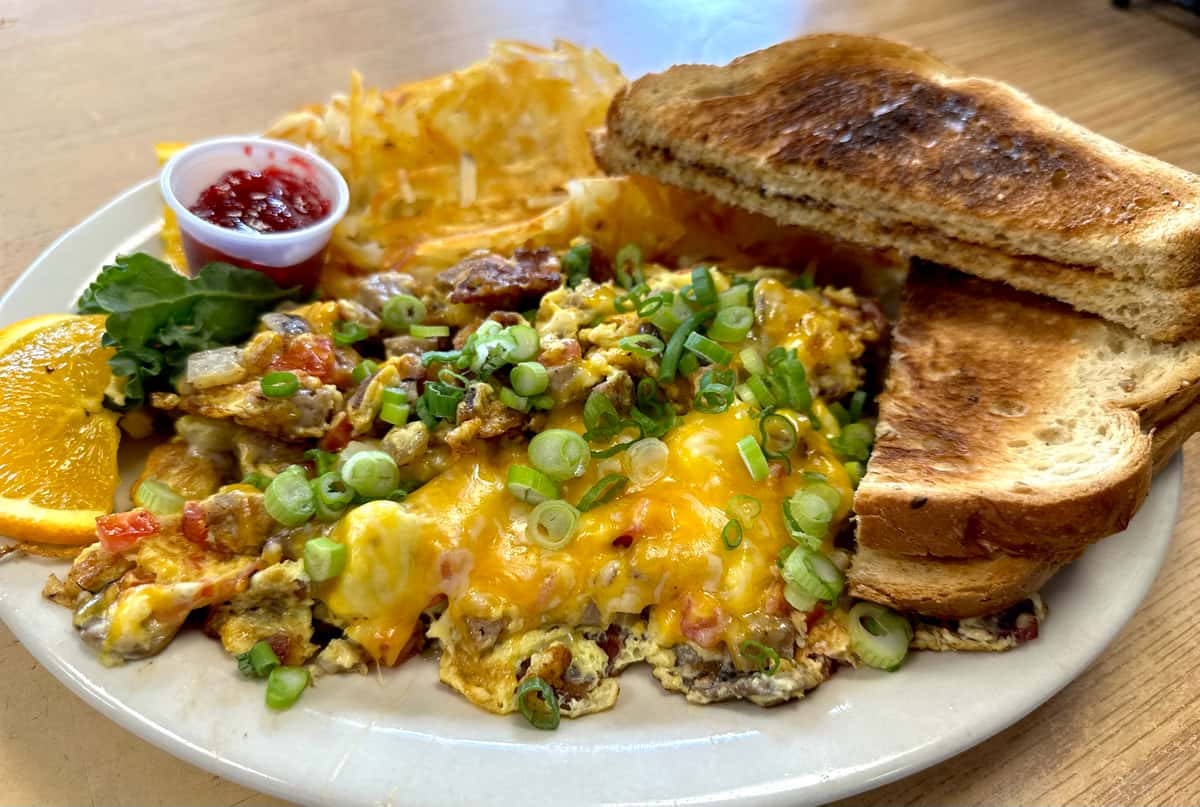 Three eggs scramble tossed with choice of meat (ham, bacon or sausage), cheese, tomatoes, mushrooms & onions.
