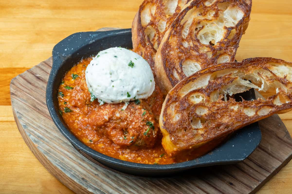 Meatballs and toasted bread with a dollop of ricotta