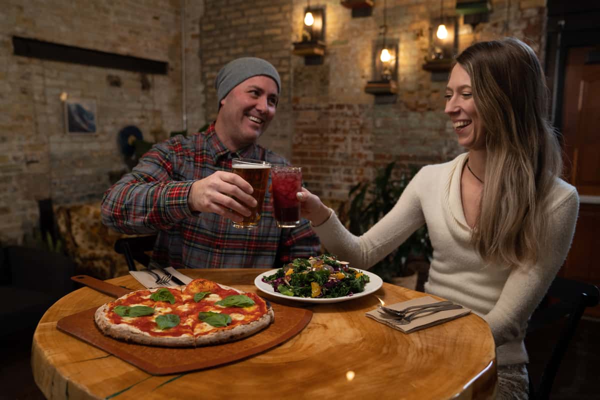 couple enjoying beer and pizza