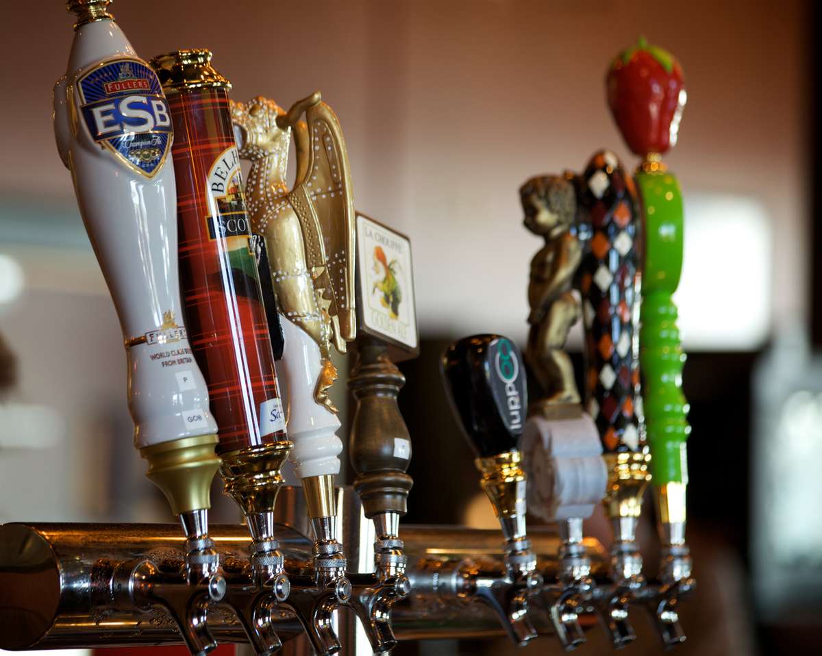 Row of beer taps on a bar counter.