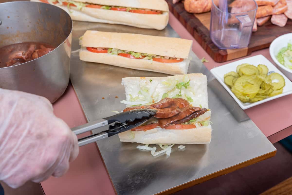 chef prepping multiple poboys