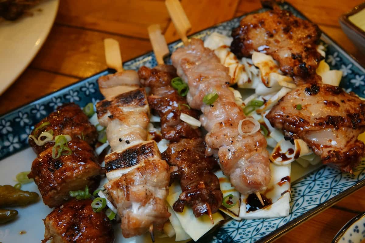 Grilled yakitori skewers topped with sesame seeds, served as part of Sumiya's signature Japanese cuisine
