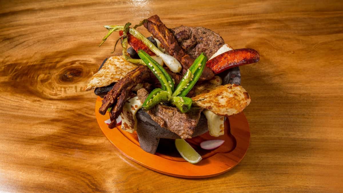 Grilled steak with roasted vegetables served on a sizzling platter.