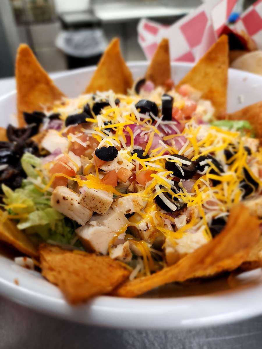 Crisp greens topped with beef or grilled chicken, cheddar cheese, diced tomatoes, onions, black olives, and salsa. Served on top of our flour chips
