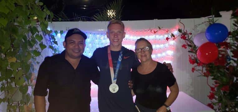 owners standing with Andrew Capobianco - USA silver medalist in diving