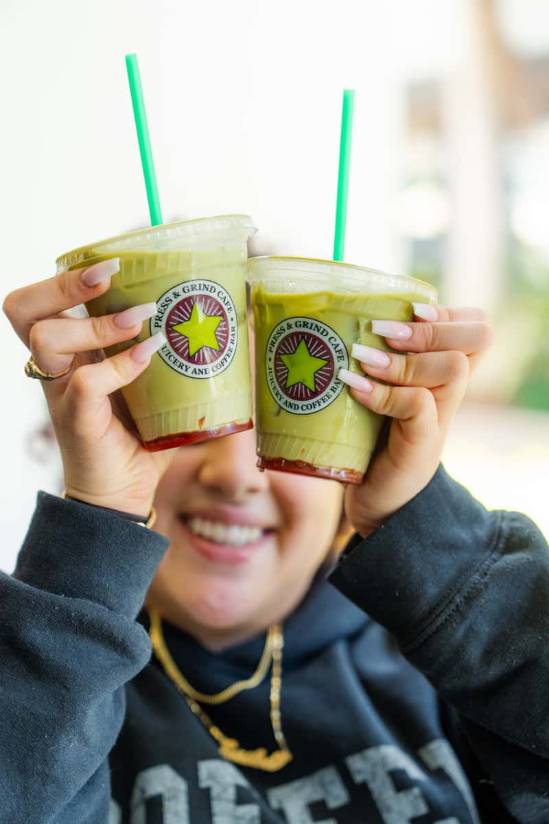 Girl holding two green drinks