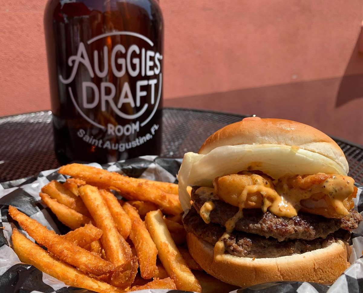 Double cheeseburger topped with fried shrimp and sauce, served with seasoned fries and an Auggie's Draft Room growler.