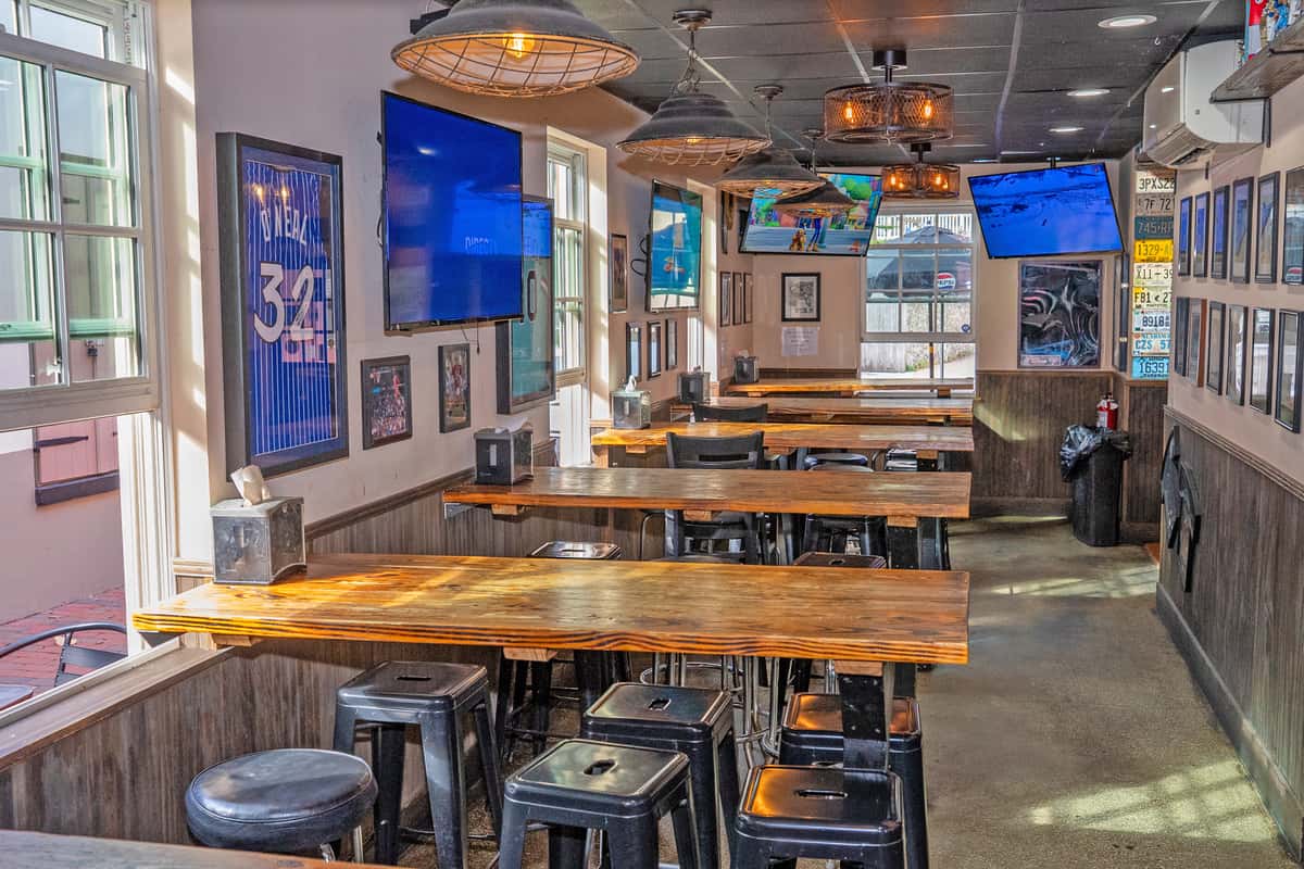 Auggie's Draft Room interior in downtown St. Augustine with self-serve beer taps, big-screen TVs, bar seating, and a lively sports bar atmosphere.