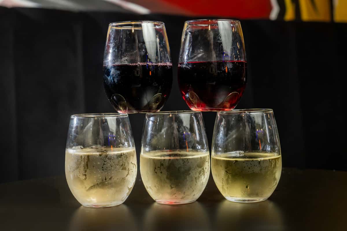 Stemless wine glasses stacked on top of each other with a black background