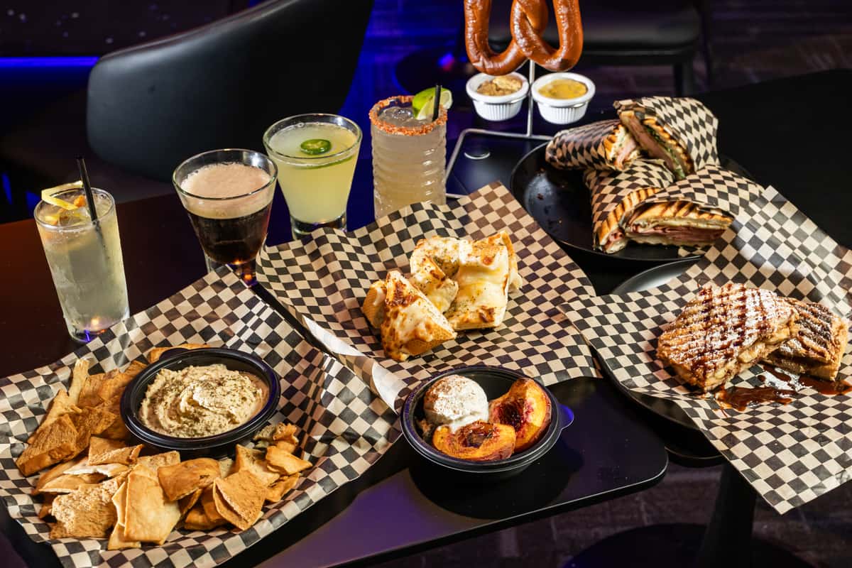 Hero setup with multiple dishes and drinks from The Riot